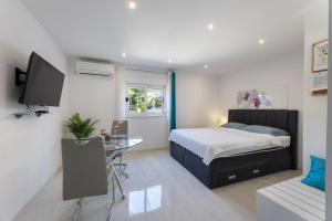 カシュテラにあるModerni studioのベッド、机、テレビのある寝室 +16枚の写真
