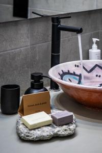 a bathroom counter with a sink and a soap dispenser at Casa Naturale in Skopelos Town