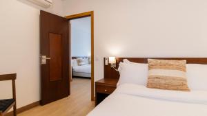 a hotel room with a bed and a mirror at Albergaria Quim Barreiros in Vila Praia de Âncora