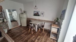 Una pequeña cocina con una mesa y un refrigerador. en Pauls Hexenhaus Wohnung Teufel mit Familienbett, en Thale