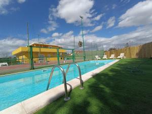 a large swimming pool with chairs and a fence at Costa di Sopra Affittacamere in Quartu SantʼElena