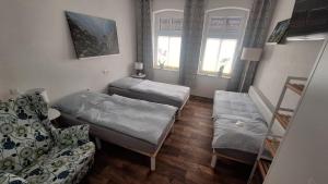 una habitación con dos camas y un sofá en Pauls Hexenhaus Wohnung Teufel mit Familienbett, en Thale