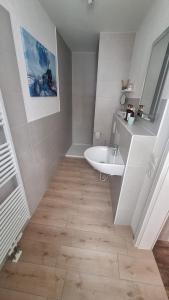 Un baño blanco con lavabo y espejo. en Pauls Hexenhaus Wohnung Teufel mit Familienbett, en Thale