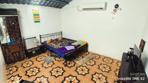 a bedroom with a bed and a wooden floor at Bougain Villa- Sinhgad fort -Bedroom- Garden- Kitchen- AC- Wi-Fi-Parking-Khadakwasala Pune in Kharakvasla
