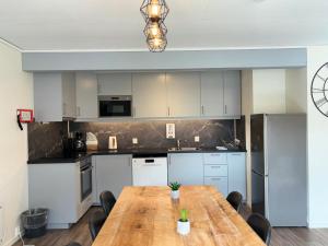 a kitchen with a wooden table in a room at Brekke Apartments in Flåm