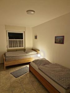 - une chambre avec 2 lits et une fenêtre dans l'établissement TBM Haus, à Hombourg