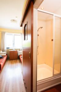 a bathroom with a shower and a glass door at Ośrodek Wypoczynkowy AGADO in Sarbinowo