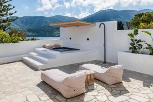 a patio with a grill and two chairs and mountains at Casa Naturale in Skopelos Town