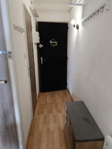 a hallway with a black door and a table at Studio agréable tout confort in Les Angles