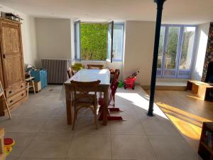 ein Wohnzimmer mit einem Tisch und einigen Stühlen in der Unterkunft Grand appartement terrasse au coeur des Bauges in Le Châtelard
