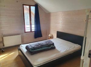ein Schlafzimmer mit einem Bett in einem Zimmer mit einem Fenster in der Unterkunft Grand appartement terrasse au coeur des Bauges in Le Châtelard