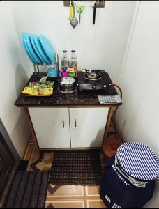 a small kitchen with a table with a stove at Bougain Villa- Sinhgad fort -Bedroom- Garden- Kitchen- AC- Wi-Fi-Parking-Khadakwasala Pune in Kharakvasla