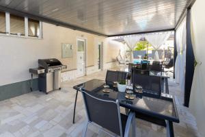 a patio with a table and chairs and a grill at Apartments Bilopavlović in Kaštela