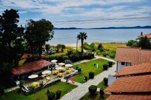歐拉努波利斯的住宿－Hotel Paradise Ouranoupolis，享有花园的空中景致,配有桌子和遮阳伞