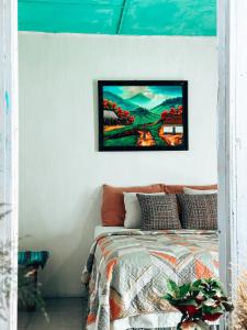 a bedroom with a bed and a painting on the wall at Casa Nicté in Flores