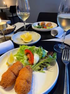 une assiette de nourriture avec du poisson et de la salade sur une table dans l'établissement HOTEL LEHOUCK, à Coxyde