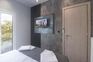 1 dormitorio con 1 cama y TV en la pared en villa-vagis, en Khalkoútsion