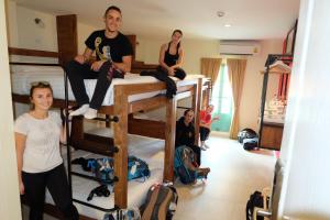 a group of people sitting on top of bunk beds at Siri Poshtel Bangkok in Bangkok