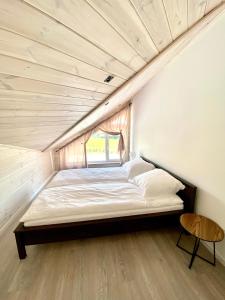 a bed in a room with a wooden ceiling at Osada Wędkarska 52/10 in Boszkowo