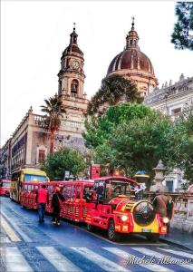 a group of red buses parked in front of a building at La Casa Delle Conchiglie in Catania