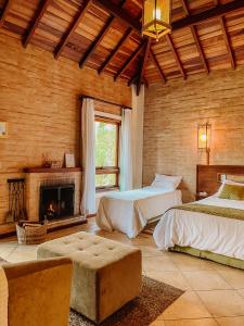 a large room with two beds and a fireplace at Pousada Bucaneve in Monte Verde