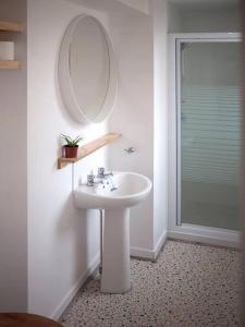 y baño con lavabo, espejo y ducha. en Contemporary City Studio Apartment 2 Minutes from Station en Aberdeen