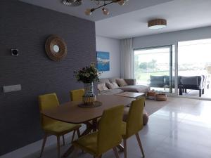 a living room with a table and yellow chairs at SOTOGRANDE Hoyo 10 in Sotogrande