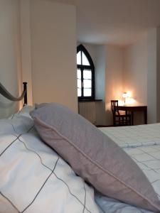 ein Schlafzimmer mit einem Bett mit einem Kissen darauf in der Unterkunft Ca' del Borgo in Abbadia Lariana
