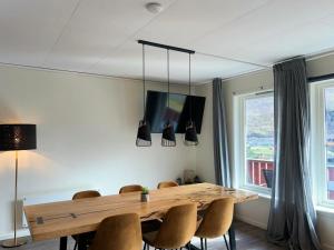 a dining room with a wooden table and chairs at Brekke Apartments in Flåm