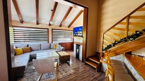 ein Wohnzimmer mit einem Sofa und einer Treppe in der Unterkunft Villa Relax Tuzla in Tuzla