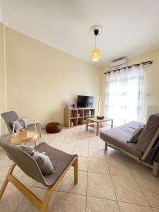 uma sala de estar com um sofá e uma cadeira em Your Home In Elefsis em Elêusis