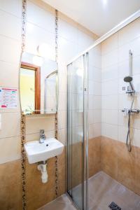 a bathroom with a sink and a shower at Ośrodek Wypoczynkowy AGADO in Sarbinowo