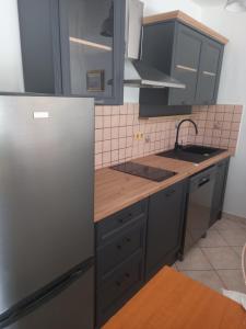 a kitchen with a stainless steel refrigerator and a sink at Roko Apartments in Selce