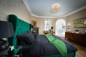 a bedroom with a large bed with a green headboard at Ardrhu House Fort William - Serviced Luxury Scots Baronial Country House in Fort William