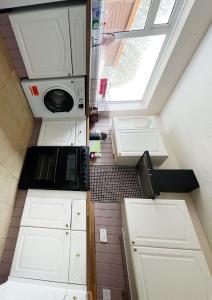 a small kitchen with white cabinets and a window at Cancel in Yeovil