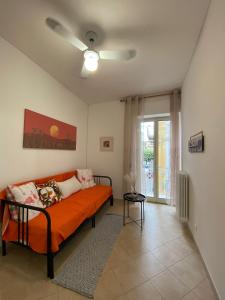 un soggiorno con divano arancione e finestra di Casa Zaira a Castellana Grotte