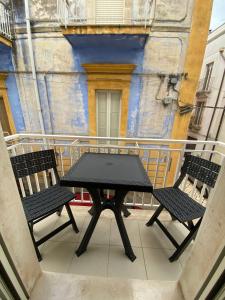 un tavolo nero e 2 sedie sul balcone di Casa Zaira a Castellana Grotte