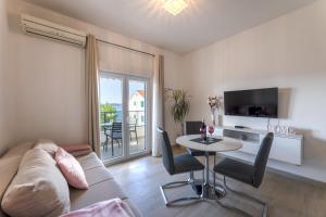 a living room with a couch and a table with chairs at Apartments Bilopavlović in Kaštela