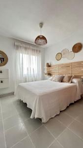 - une chambre blanche avec un grand lit et une fenêtre dans l'établissement Calle Larga 43/2, à La Adrada