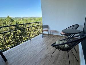 a balcony with two chairs and a table and a view at Apartman 103 in Vrdnik