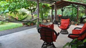 two chairs and a hammock on a patio at Casa Arboleda-Full House by the River and Forest and Gardens in San Francisco