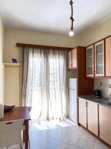 uma cozinha com uma grande janela e uma mesa em Your Home In Elefsis em Elêusis