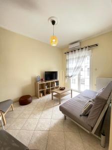 uma sala de estar com uma cama e uma televisão em Your Home In Elefsis em Elêusis