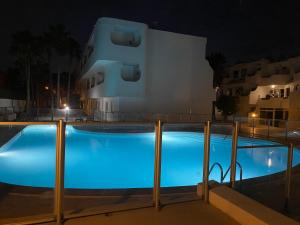 a large blue swimming pool in front of a building at night at Océano Fuerte in Costa de Antigua