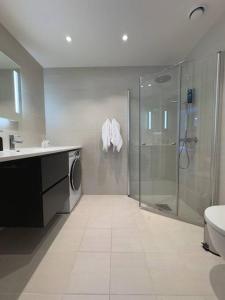 a bathroom with a shower and a washing machine at Moderne 3 Roms leilighet i Oslobukta! in Oslo +18 photos