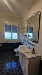 a bathroom with a sink and a toilet and a mirror at Villa Rosario in La Iruela
