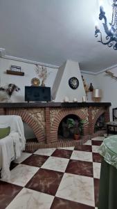 a living room with a brick fireplace with a clock at Villa Rosario in La Iruela