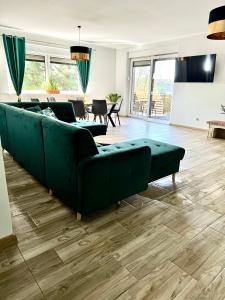 a living room with a green couch and a table at Zielona Mila in Sępólno Krajeńskie