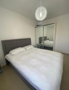 a bedroom with a large white bed and a mirror at Duplex piscine privée in Eilat