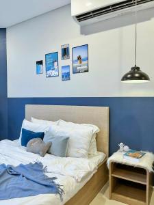 Schlafzimmer mit einem Bett mit blauen und weißen Wänden in der Unterkunft Căn hộ The Sóng Vũng Tàu in Vũng Tàu